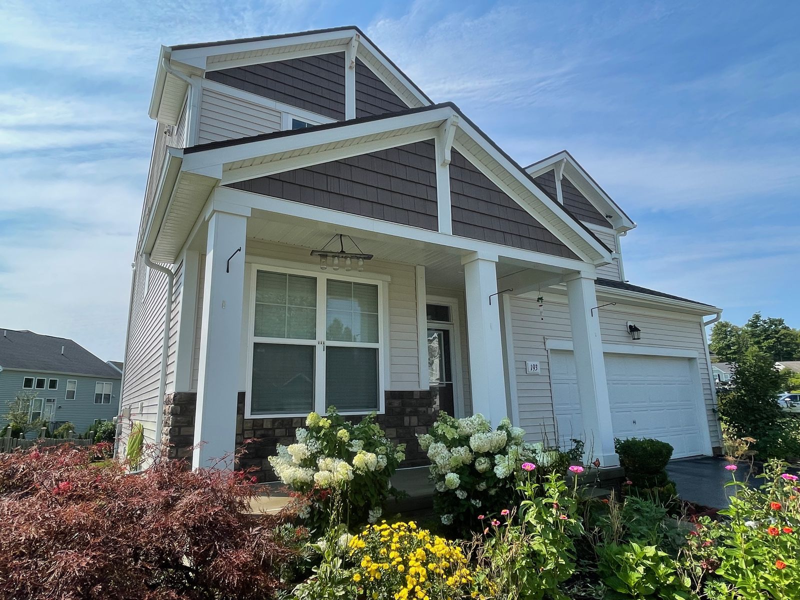 Craftsman-style home with clean siding and summer flowers